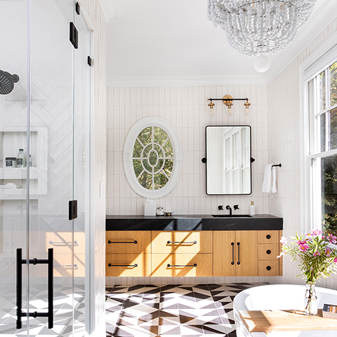 Black and white primary bath renovation with rift sawn oak cabinetry, soapstone countertops, concrete tile floors and floor to ceiling stacked vertical wall tile
